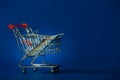 Mini, toy shopping cart trolly with a stack of plastic credit debit cards placed in the basket Royalty Free Stock Photo