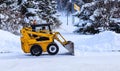 Mini tractor removes snow on the streets of the city