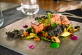 Mini tuna steaks with microgreens and potato side dish on a ceramic plate