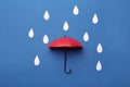 Mini umbrella and paper raindrops on blue background, flat lay Royalty Free Stock Photo