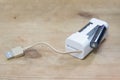 Mini USB Battery Charger for Rechargeable AA/AAA Ni-Mh and Ni-Cd Batteries on a wooden surface Royalty Free Stock Photo