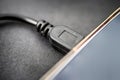 Mini usb cable connected to digital tablet closeup view Royalty Free Stock Photo
