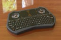 Mini Wireless Bluetooth Keyboard on the wooden table, 3D rendering