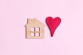 mini wooden house symbol and red heart on wooden background, top view, flat lay Royalty Free Stock Photo