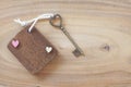 Mini wooden tag with beautiful antique heart shape key on wood background. Welcome to new home, home sweet home concept