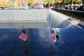 Miniature American flags and flowers at World Trade Center Memorial in New York. Royalty Free Stock Photo