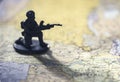 Miniature armed soldier with gun on map, symbol of war conflict