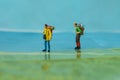 Miniature backpackers walking on map as background travel concept