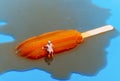 miniature bather man on a melting orange popsicle