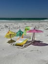 Miniature beach chair and umbrellas on beach sand