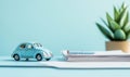 Miniature blue car on desk with documents and pen, showcasing organization and planning Royalty Free Stock Photo