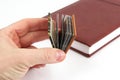 Miniature book in hand on a background of the usual books Royalty Free Stock Photo
