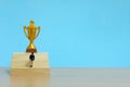 Miniature business concept - businessman walking on staircase to reach golden trophy Royalty Free Stock Photo