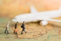 Miniature business people : businesses team waiting for plane on world map using as background travel. Royalty Free Stock Photo