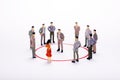 Miniature business people in conection scheme over white backdrop or background. Royalty Free Stock Photo