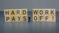 miniature businessman figure with hard work will pay off text