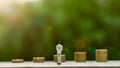 Miniature businessman figure standing for see the future front a golden coins. - Finance and loan concept