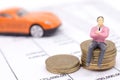 Miniature businessman and stack coins on statement and the car b Royalty Free Stock Photo