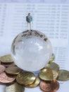 Miniature businessman stand on globe of glass, Euro coins and bo Royalty Free Stock Photo