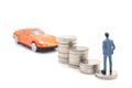 Miniature businessman standing on coins and the car behind. saving and loan concept. Royalty Free Stock Photo