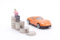 Miniature businessman standing on coins and the car behind. saving and loan concept. Royalty Free Stock Photo