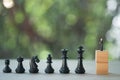 Miniature businessman standing and encounter in front of black chess. Concept of business analysis and strategy