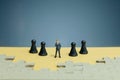 Miniature of businessman standing in the middle on chess army line with jigsaw puzzle