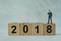 miniature businessmen thinking and standing on wooden block 2018 with white background as happy business new year concept Royalty Free Stock Photo