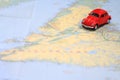 Miniature car driving on a map of Newfoundland Canada