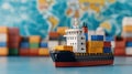 A miniature cargo ship with colorful containers against a world map background Royalty Free Stock Photo