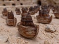 Miniature ceramic boats on sandy surface