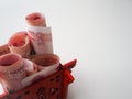 Miniature Chinese pavilion in bright red filled with Chinese 100 renminbi banknotes against a white background