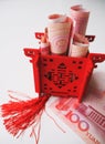 Miniature Chinese pavilion in bright red standing on and filled with Chinese 100 renminbi banknotes