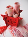 Miniature Chinese pavilion in bright red standing on and filled with Chinese 100 renminbi banknotes