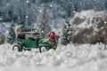 Miniature classic car carrying a christmas tree on snowy winter landscape Royalty Free Stock Photo