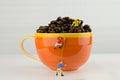 Miniature climbers climbing coffee cup