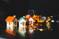 Miniature colorful house with golden stack coins on construction