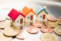 Miniature colorful house on stack coins