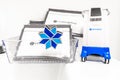 Miniature Coolsculpting machine model, next to Coolsculpting logo pin and packets, in a medspa.