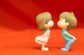 The Miniature Couple dolls Boy and Girl Romantic Kiss on Red Background for valentine`s Day Concept