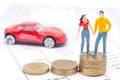 Miniature couple people and stack coins on statement and the car