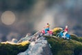 Miniature couple traveling through the countryside on vintage motorcycles at dawn