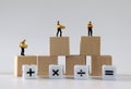 Miniature courier drivers standing on wooden blocks and white cubes with an arithmetic operation symbol.