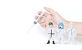 Miniature doctors team in protective suit standing over syringe in girl hand on white background