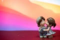 Miniature doll couple boy and girl kissing each other with love with colorful background