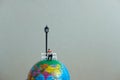 Miniature education concept for study abroad - young student reading above globe Royalty Free Stock Photo