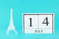 Miniature of the Eiffel Tower and wooden calendar on a blue background. The concept of the holiday is July 14, the Day of the Bast Royalty Free Stock Photo