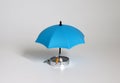 The miniature elderly couple sitting on the compass and the blue umbrella.