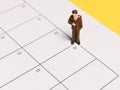 Miniature employee stand on blank calender. Payday and payment of salary concept.