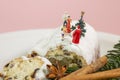 A miniature family is celebrating christmas on top of an powdered fruit cake